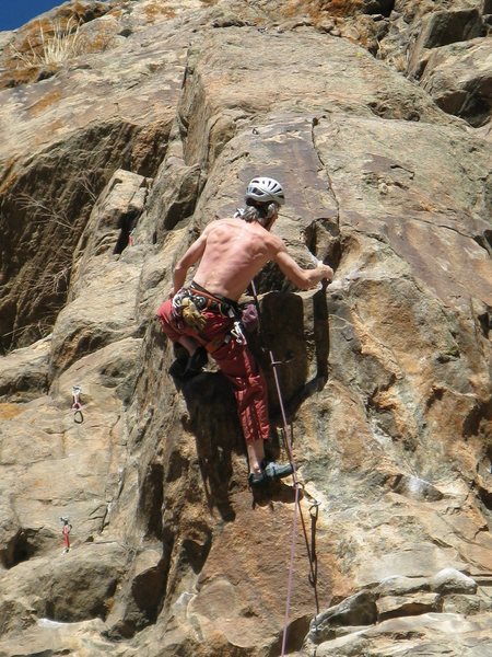Pulling left around the arête is the first hard move.<br>
Photo by Ken Parker.
