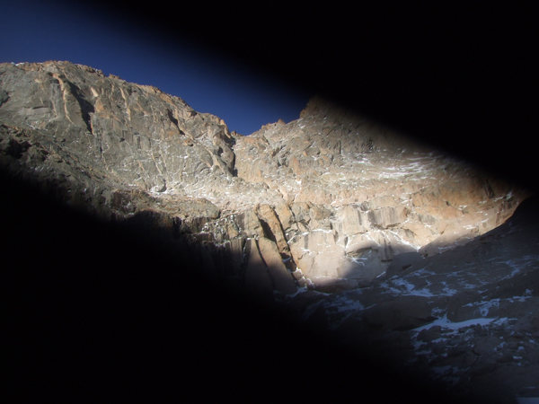 Bad picture of the route from a distance (shutter problems on camera). The route starts in the obvious, large dihedral and follows the left branch through an OW to the huge ledge splitting the face. Then follow the chimney.