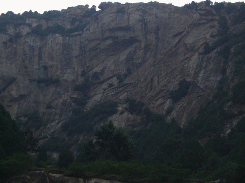 A completely unclimbed wall 100m down the road from Lao Yan Chang, just waiting for your FA. The wall looks to be 300ft+.
