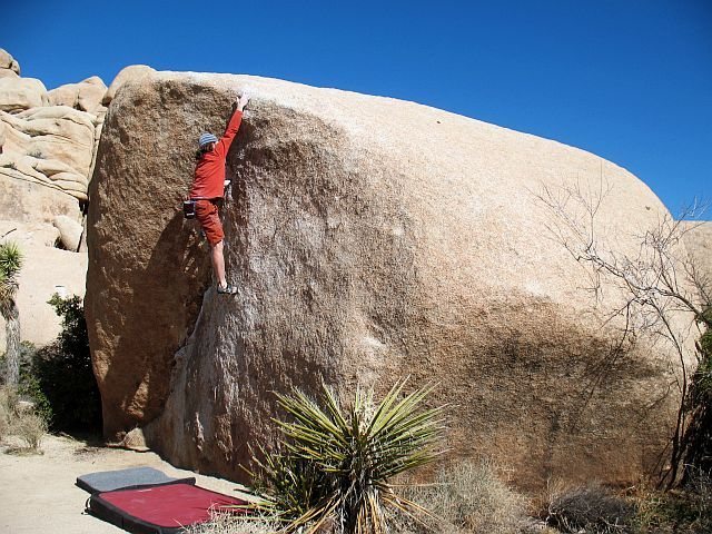 Reaching for the sloping lip of The Chube (V0+), Joshua Tree NP
