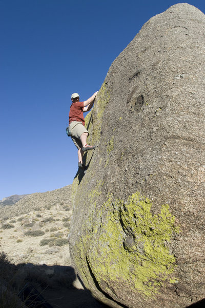 V2 highball with a tricky mantle start (much easier up high), accessed through a corridor on the north side of the main cluster (tops out just above the knob problem). Very bad landing.