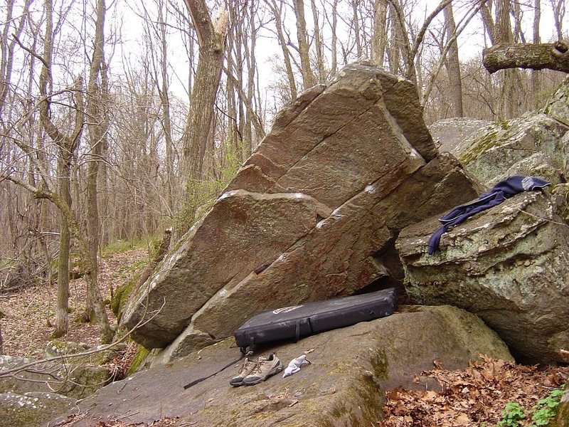 Overhanging Boulder uphill and more or less in the center of the Group A boulder cluster. The overhanging face faces north. Problems start in a pit. Worth a session if you have done everything else.
