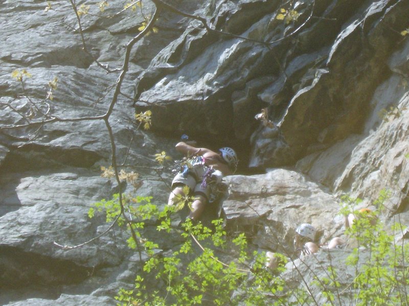 Detail of climber making the crux moves near the end of the first pitch. Look for this identifying feature you can see from the ground. Belay just above this roof/alcove.