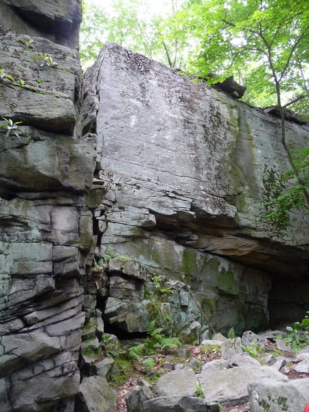 The Brutal Block. The Face of Reality, 12a, goes up the clean face to the right of the Arete. The Matrix, 11c, climbs out the roof and then up the right facing corner which is now much cleaner than appears in the photo.