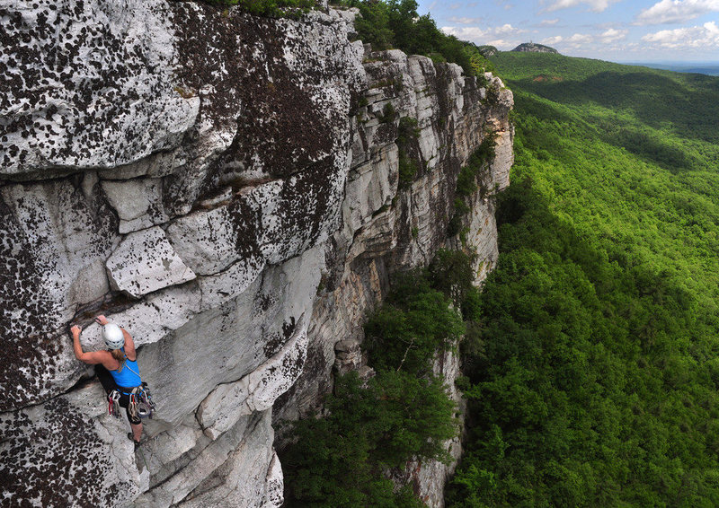 Eve exiting on the 5.6 variation. The crux 5.9 section is slightly below her and to the right, on the small, clean ledge below the lichen-encrusted bulge.