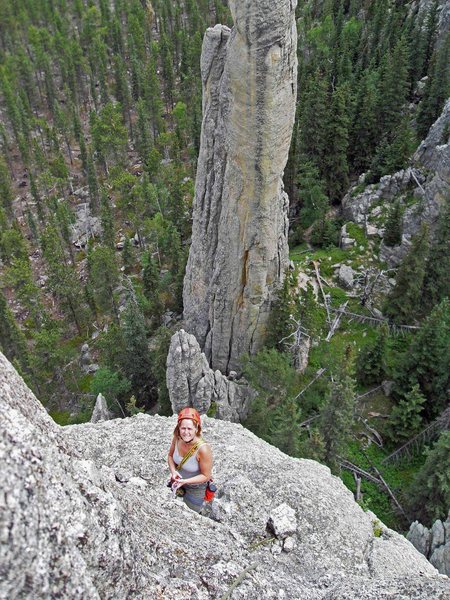 Looking down from the summit block to Brenda standing at the bolts at the top of pitch 3. The narrow spire in the background is "Station 13."