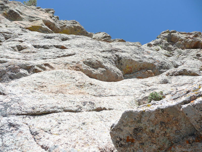 Photo taken from the belay at the top of our Pitch 5. Pitch 6 trends rightward and then turns up before reaching the outcrop of rocks against the sky in the upper right of the photo.