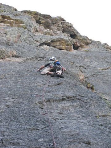 The direct start climbs a clean face just to the right of the flake system. The large roof seen up and right from climber in this picture comes just after the crux, on P2. The first belay is up and right 60 or 70 feet from the climber's position.