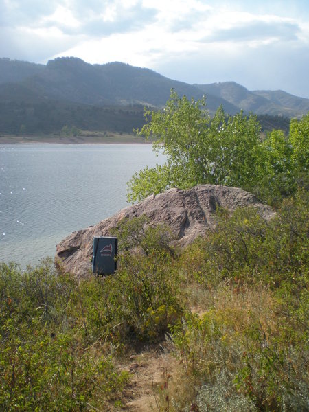 Right behind the boulder.