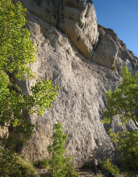 The central, money section of the Cowboy Poetry cliff on a warm Indian Summer morning.<br>
<br>
Take Your Had Off Boy begins just left of the climber, and Buffalo Soldier begins just to the right (around the bushes).