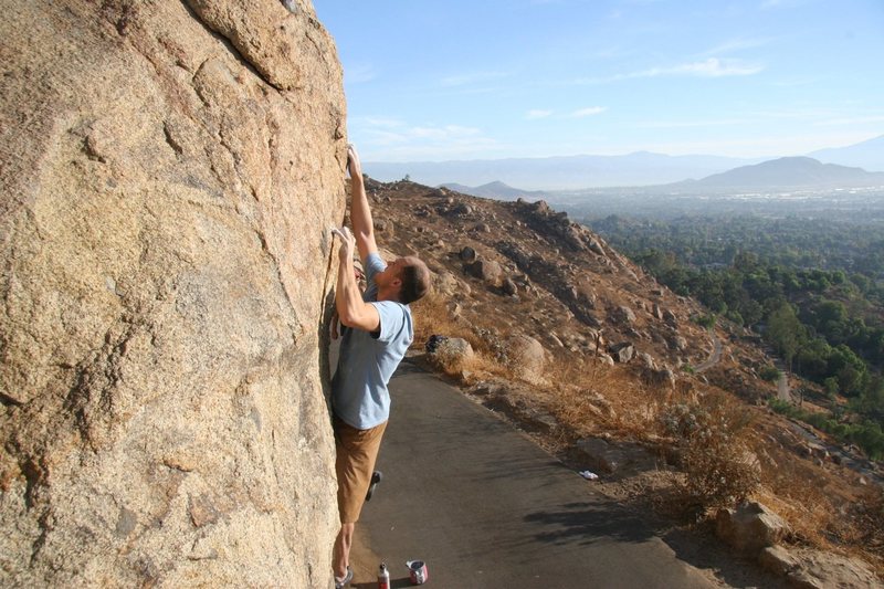 Ryan pulling on the crux crimp on Borson's Leftside, V1