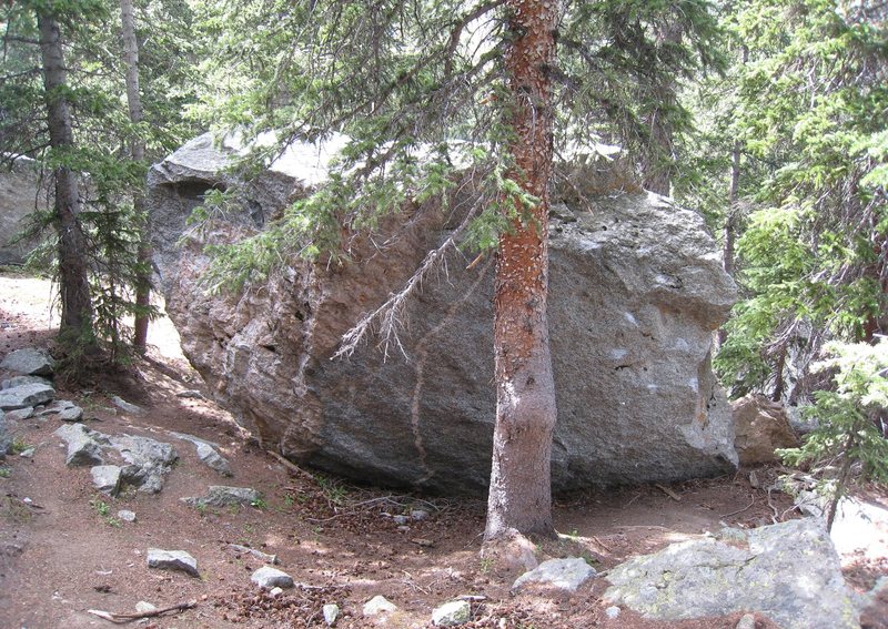 In the woods uphill from Seurat/Chocolate Croissant. This boulder might have more than one problem on it.