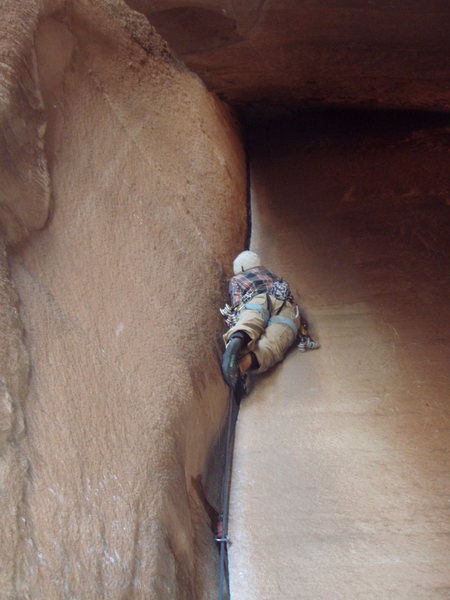 Ginger climbing toward the darkness, Cave Route, Indian Creek
