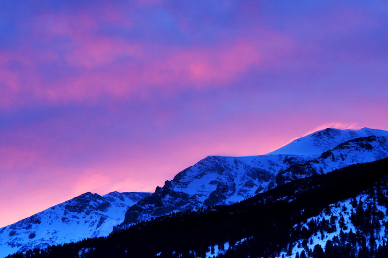 Spindrift lit with alpenglow high on a ridge in Rocky Mountain National Park.
