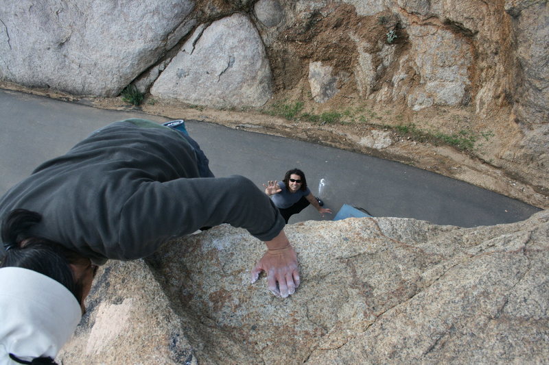 Albert on the north end roadside boulders topping out with RastaRaj on spot below.. 2-7-10