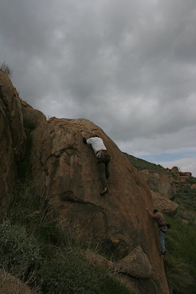 Me doing the easier problem on the left side, with Nathan working on the harder part. This boulder is down below the trail in the Accomazzo Boulders Area. 2-21-10