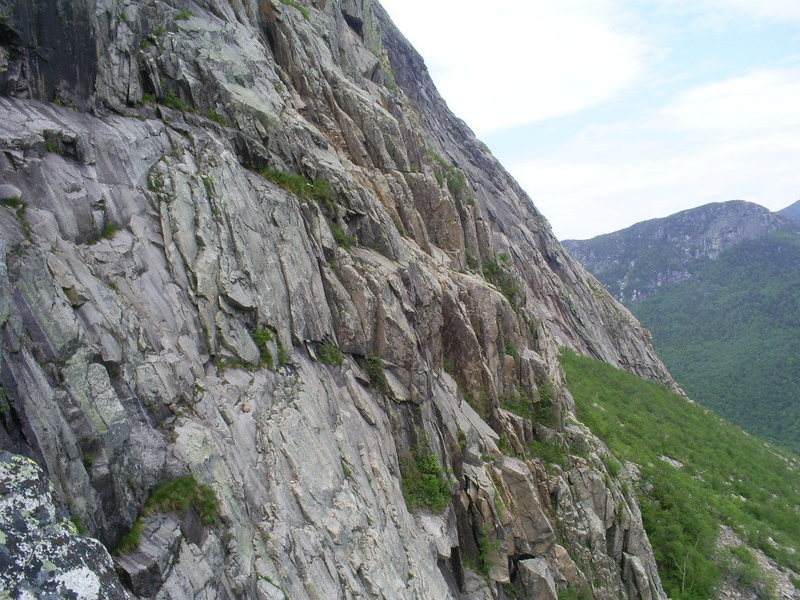 To the right of the bushes in the foreground is 'The Odessa Steps (often wet)' To the right of that is Bull Dog on the crest of the greenish ledges heading towards the second group of bushes. Left of those bushes is a corner. Ascend the outside of the corner up to the smallest dark rock and bushes. The large rock in the corner is now gone. There are variations to be had, including the corner now to be climbed.