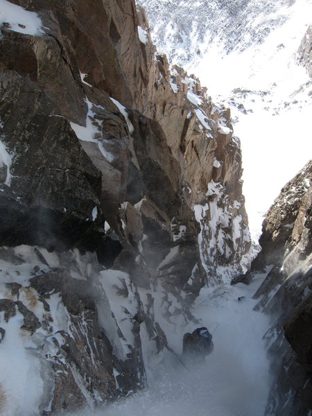 Looking down from the crux, Bill Duncan experiencing the gully in heavy spindrift.