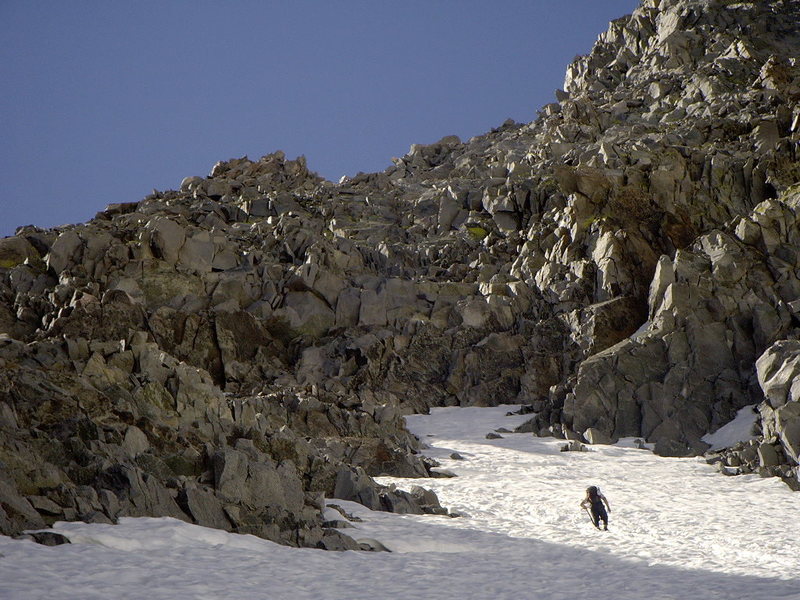 Climbing out of the glacial bowl. The loose rock band above separates the glacier from the L-shaped col.