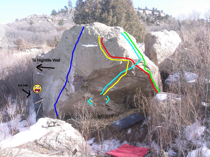 Urban Adventure Boulder.<br>
<br>
On the way to Punani Boulders before the bridge.<br>
<br>
Blue line: Wacky Waving Inflatable Flailing Armed Tube Man, V2. Start low under lip gain over lip once into slab easy V2 for the rest.<br>
<br>
L. blue line: Snow Shoes, V4. Sds make way up to slopers then to pocketish side pull to right hand crimp. Up to top crimp jug match move out to right gain a high right mantle to finsih. PG-13 - R if you blow the mantle you'll land right on rock under problem.<br>
<br>
Red line: A River Runs Through it, V5. SDS. Start on holds on next picture make way up crimps and arete move out higher to left match in huge juge move out to sloper flat cobble hand heel match mantle out to top jug. PG-13 if you blow the mantle.<br>
<br>
Yellow line: Avalance ,V? (Open Project). Start as Snowshoes then from pocket sidepull and right crimp on rail dyno up to jug finish ARRTI.<br>
<br>
L. green loine: Dry Ice, V3+. Start same as RRRTI finish off Snowshoes.