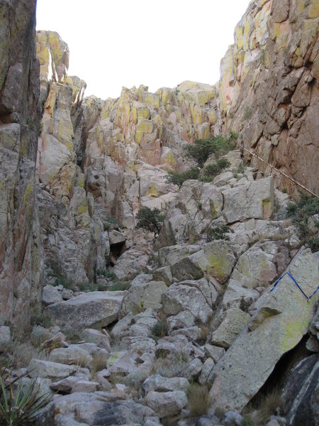 Looking up from the top of the first chock-stone. The rap anchor on the right may be used to protect followers coming up the right (easy) side, but there is another rap anchor on the left that I used to bring folks up the left (harder) side.