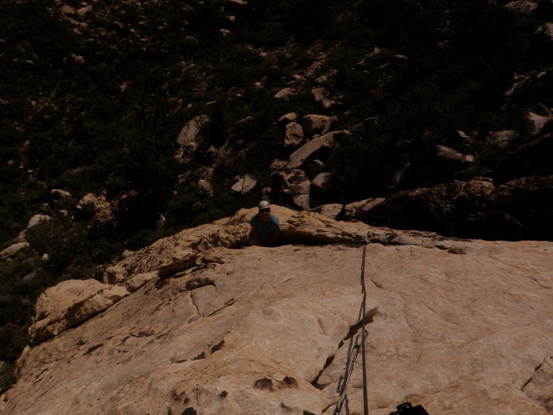 Jesse Patchett at the belay ledge at the top of Pitch 1 of Pillar Talk.
