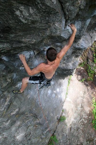 Kevin latching the jug on the lower boulder problem