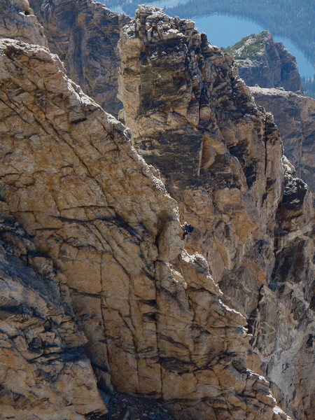 A climber on the Petzoldt Ridge, with the Teepee Pillar and Bradley Lake in the background, as viewed from the Direct Exum.