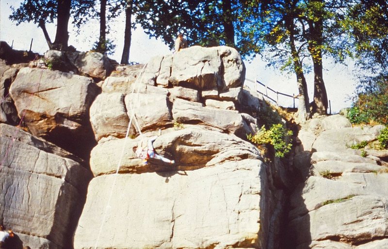 An old picture of a climber on the top overhang on Hate.