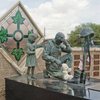 4th ID commissioned statue of remembrance. <br>
<br>
Depicts Iraqi child thanking a US soldier for liberating the country from Saddam. <br>
<br>
The materials used were from Saddam statues, as well as the artisan, but disputed Iraqi artisan stated it was all about the money for him as to its purpose.