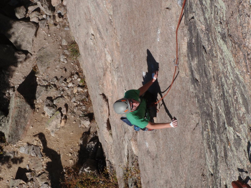 Chris contemplating the slab moves up the thin, left-facing seam.