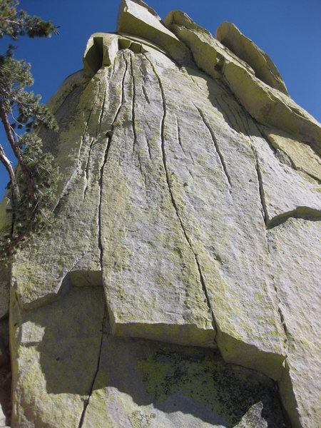 Pinhead climbs the thin crack on the left through the lower roof and directly up to the higher roof, passing a small bush.