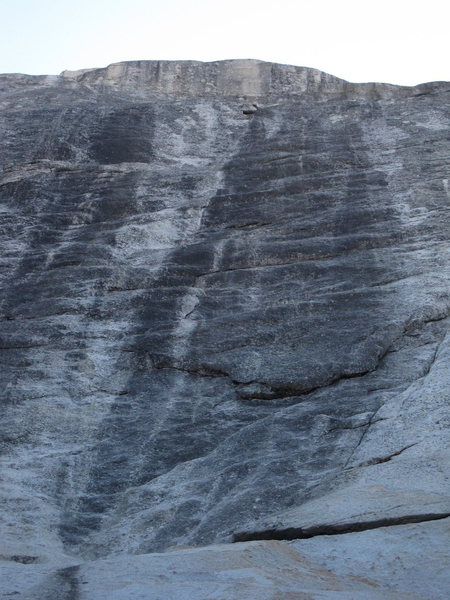 In this photo you can see (in the order they are described in the description): the right leaning ramp; the downward pointing flake; first right facing flake (in white rock to the immediate right of the prominent black streak); second left facing flake (in the black streak); and the white area. You then head up and right to the first bolt.