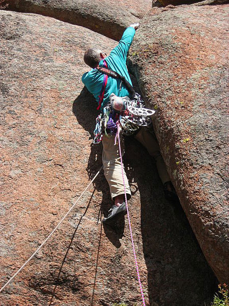 Working the crux... early attempt, 2009. This was the wrong way to climb this route. Keep the right arm low, and go for it.