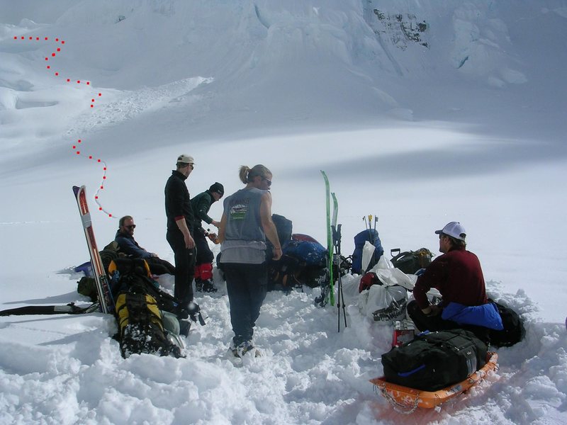 Three expeditions waiting in the middle of the horseshoe for Paul Roderick. Even after we packed the run-way, he took two blustery "grooming passes" around us, before stopping for pick-up on the third landing. <br>
<br>
The disappearing dots in the backround are where the second serac avalanche wasted the approach trail.<br>
<br>
Scott, Mark, Leo, Aden, and Paul.