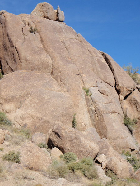 100 foot wide, split into three sections by two chimneys. Climb past first bolt, past two horizontal seams and a then to a perched boulder to a the base of handcrack leading to a short headwall. Single Rope Descent.