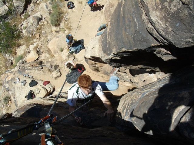 View from the top. Eric about to top the route, with view of belaying area underneath him.