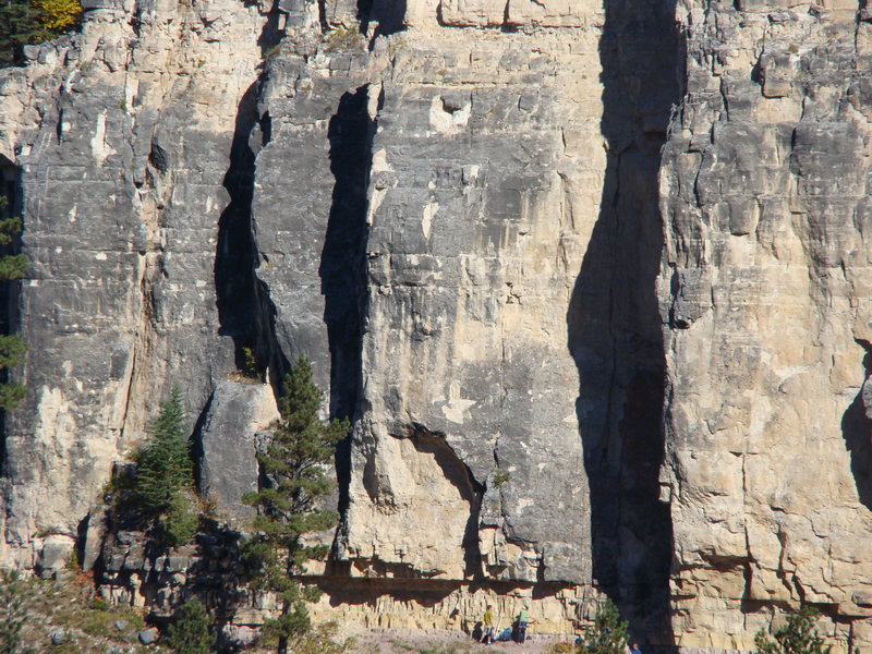 Do these crack climbs! Climber in the green shirt and shorts is at the start for Himalayback. Climber in blue shirt and black pants is right below the start for Cranium Crack. Move right and you'll see some great 5.12's until you reach Ka-Pow! Move left and you'll see some airy 5.12's until you get to Base Camp which is behind the shorter spruce tree to the left of this photo. Tasting Time is to the left of Base Camp.