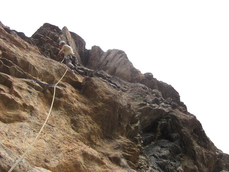 Just above the 5.11 roof on P4 tip toein' through the short, rotten band. The arete looms above.