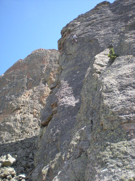 Paul moves past the 4th bolt on 'The Green Wave'. The Upper Great Face is visible to the left.