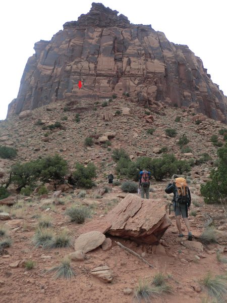 Selfish Wall as seen from the approach trail, after parking at the fork in the road and turing left. Red arrow shows the top of Hand Solo, white calcite at base of route easily seen from below
