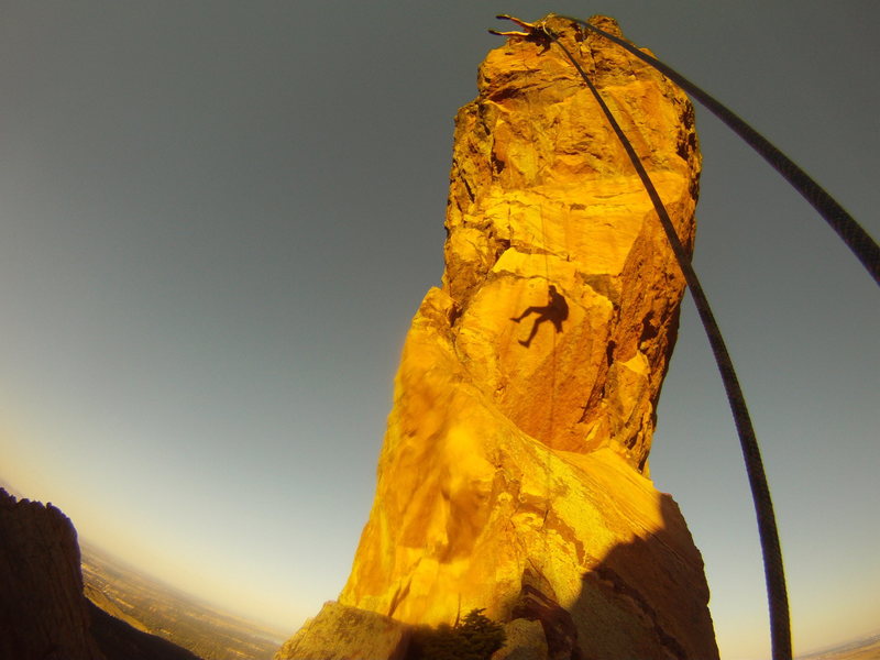 The rappel to the crows nest. Climber: K. Decker. Looking Northeast towards boulder at the direct west face of The Maiden.