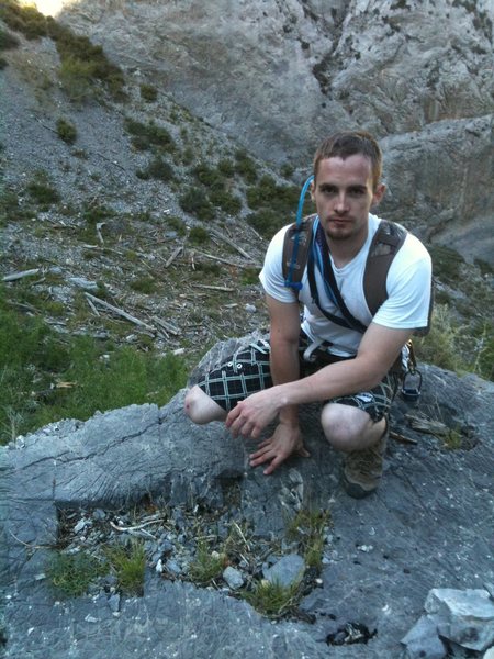 Me sitting on a rocky ledge underneath imagination wall at Mt. Charleston.