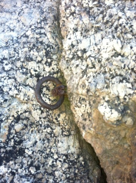 The old ring piton at the top of the finger crack before a few faces moves to the ledge.