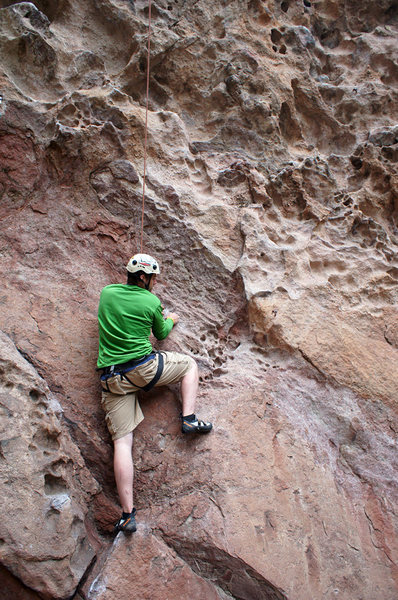 Climber starting up Big Bob Cranks on Dinosaur Rock.