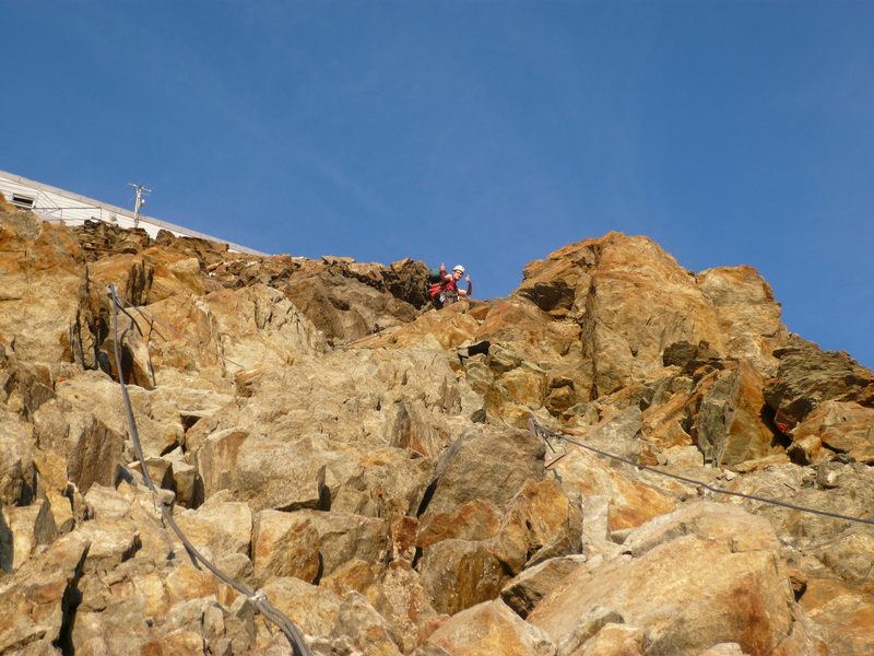 Approaching the Refuge du Goûter. Fixed cables are visible which help to secure the easy scramble.