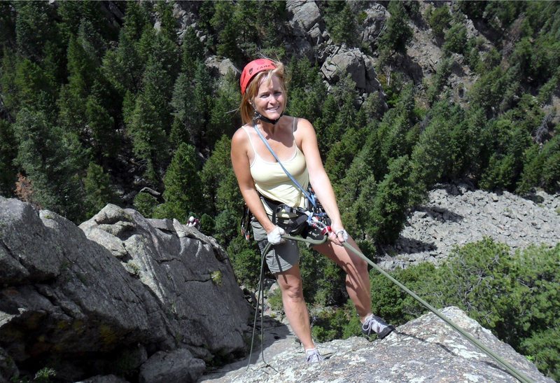 Brenda rappels Hollow Man with a climber on Handcrack Arete in the background.
