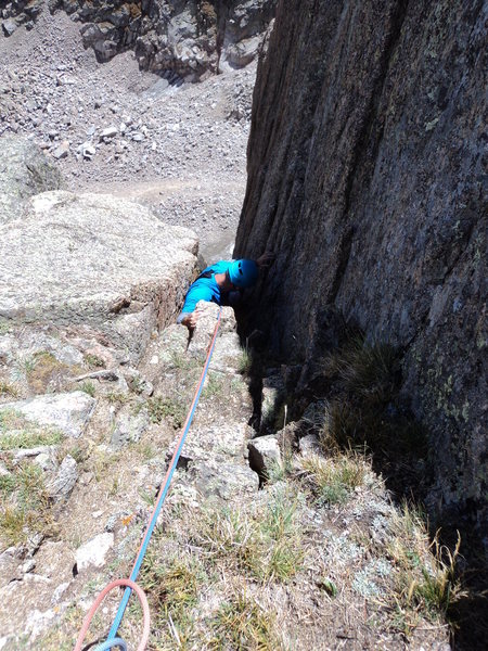 Joe emerges from the chimney at the top of P4. He is hanging the pack below him for the short squeeze sections at the top of this pitch.