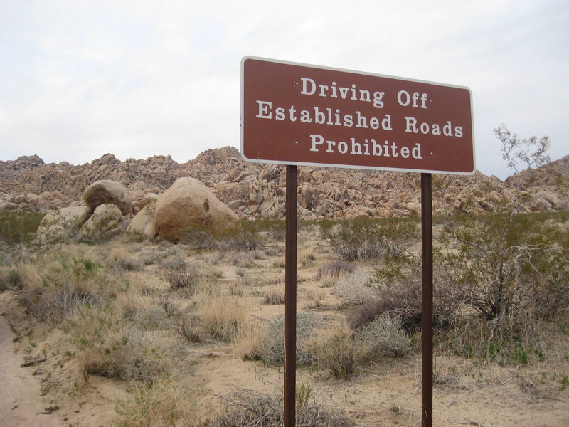 The sign where you can park to walk out to Lehi's Wilderness seen in the background of this photo is Scout Rock.