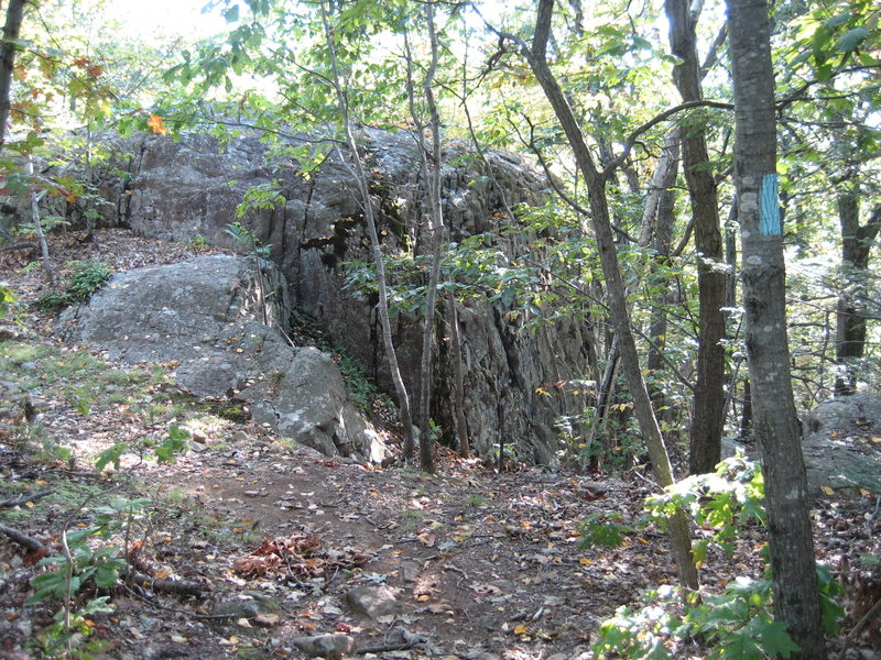 Hiking south, the Metacomet trail goes up over the top of the crag. Descend right for crag base.